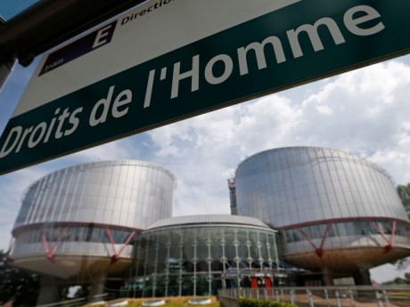 A board at a tram stop reads "Human rights" in front of the European Court of Human Rights in Strasbourg