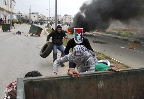 883287_palestinian-stone-throwers-take-cover-during-clashes-with-israeli-troops-near-ramallah
