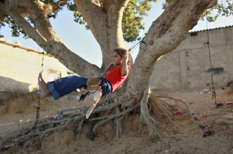 A Palestinian girl plays on a makeshift swing in Khan Younis in the southern Gaza Strip
